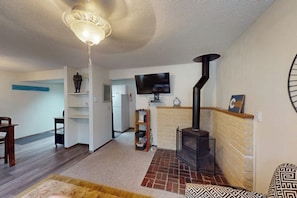 Ein Wohnzimmer mit Kamin, Fernseher und Deckenventilator.