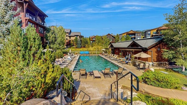 Un resort con piscina, sedie a sdraio e una scala che conduce alla piscina.