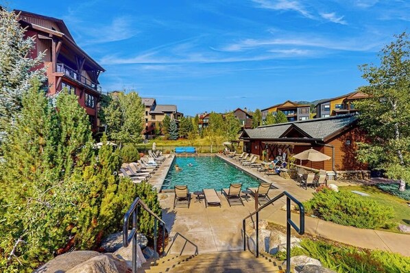Ein Resort mit Schwimmbad, Liegestühlen und einer Treppe, die zum Pool führt.