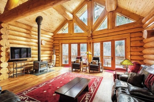 Luxurious log cabin with river views, hot tub, firepit, outdoor areas, & W/D