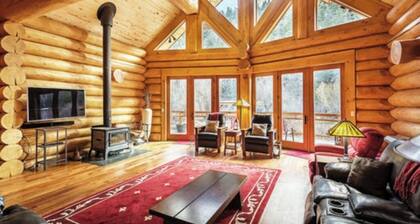 Luxurious log cabin with river views, hot tub, firepit, outdoor areas, & W/D