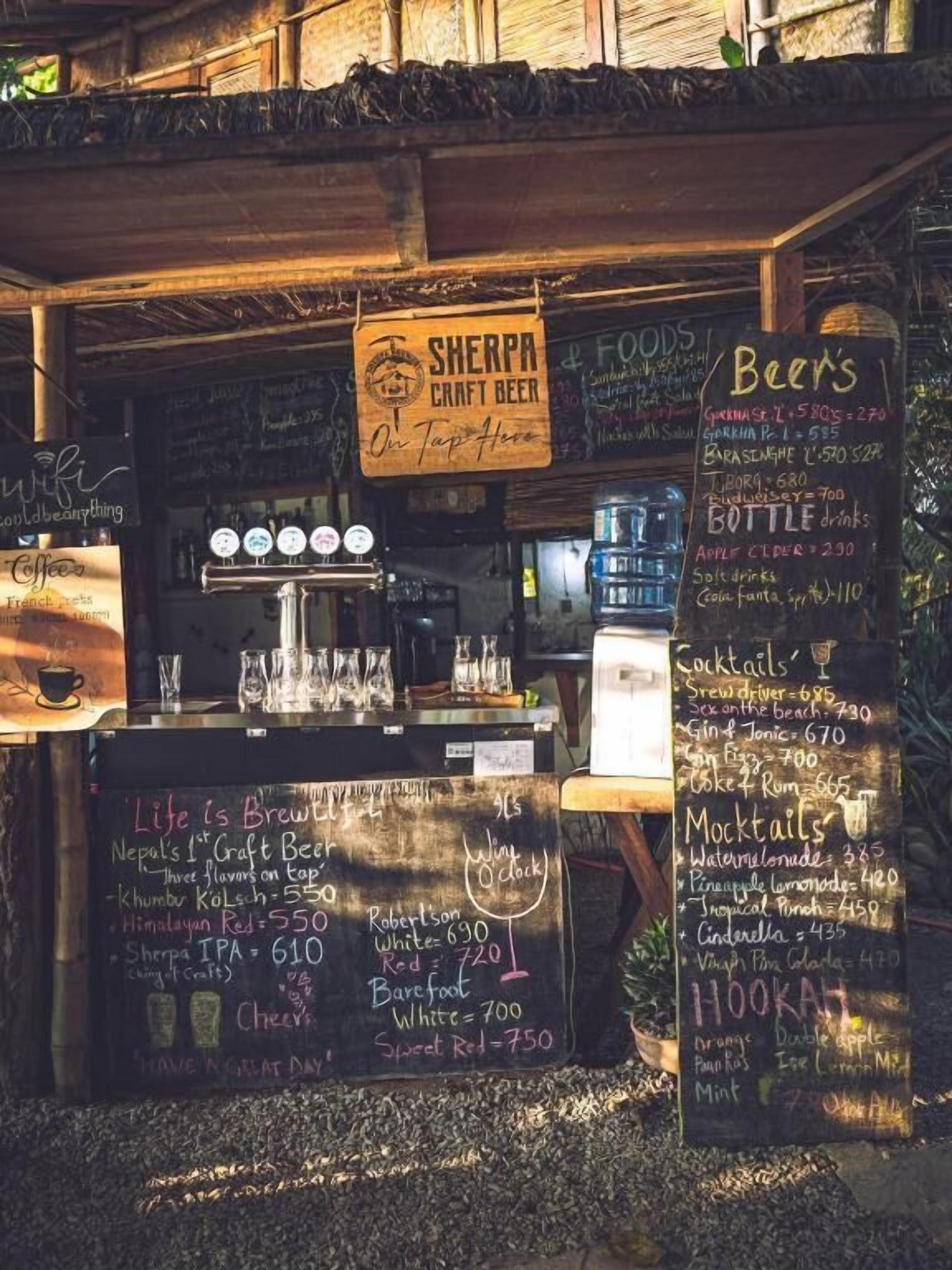 A craft beer tap area with a chalkboard menu listing various beers and prices.