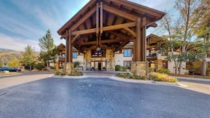 Eine Lodge mit überdachter Veranda, Steinwänden und Blick auf die umliegende Landschaft.