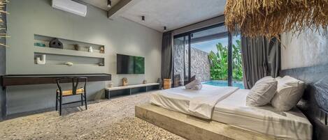 Un dormitorio moderno con cama, escritorio y televisor.