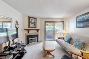 Ein Wohnzimmer mit Flachbildfernseher, Kamin, einer Couch und einem Esstisch.