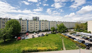 Ein mehrstöckiges Wohngebäude mit Parkplatz und Grünflächen.