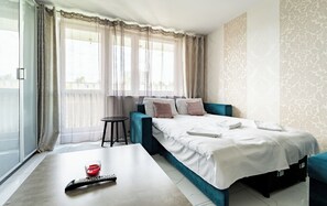 Ein Hotelzimmer mit einem Bett, einem kleinen Tisch, einer Fernbedienung und einem Glas mit Kerze.
