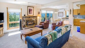 Amplia sala de estar con chimenea, sofá, una mesa de centro y televisor.