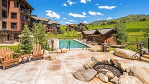 Un complexe hôtelier doté d’une piscine, d’un espace extérieur aménagé et offrant une vue sur les montagnes.