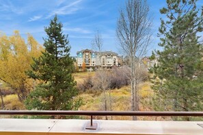 A multi-story building with a balcony, surrounded by trees and a clear sky. - Lovely, modern getaway for the whole family w/ a shared pool & gym (Steamboat Springs)