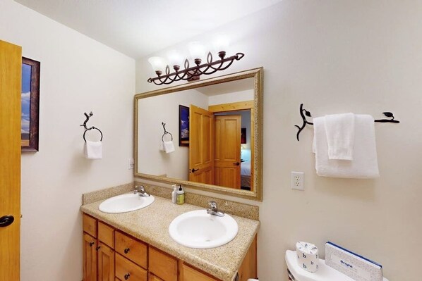 A bathroom with two sinks, a large mirror, and a towel rack. - Canyon Creek B103 - Family-friendly getaway w/ a private balcony, shared pool, hot tub, & gym (Steamboat Springs)