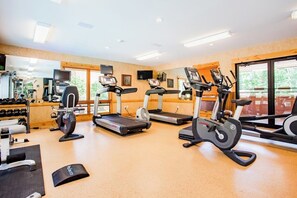 Ein Fitnessstudio mit Laufbändern, Crosstrainern und Gewichten.