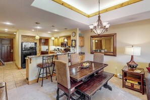 A kitchen with wooden cabinets, a dining table, and chairs. - Top-floor mountain condo w/ a shared, heated pool, hot tub, & fitness room (Steamboat Springs)