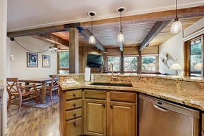A kitchen with wooden cabinets, a granite countertop, and pendant lighting. - Clean Steamboat suite with washer/dryer, pool & hot tubs - near ski base (Steamboat Springs)