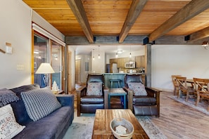 A living room with a sofa, two armchairs, a coffee table, and a dining area with wooden chairs and a table. - Clean Steamboat suite with washer/dryer, pool & hot tubs - near ski base (Steamboat Springs)