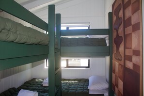 A bunk bed room with two beds and a window.