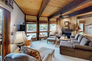 Ein gemütliches Wohnzimmer mit Kamin, Holzbalken und bequemen Sitzmöglichkeiten.