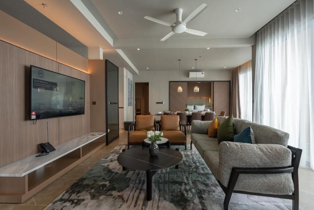 A modern living room with a flat-screen TV, a ceiling fan, a sofa, and a coffee table.