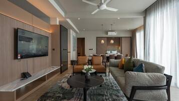 A modern living room with a flat-screen TV, a ceiling fan, a sofa, and a coffee table.