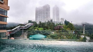 A hotel with a view of two tall buildings, a pool, and a staircase leading to the entrance. - Antara Genting by Harvinton Mansion (Bentong)