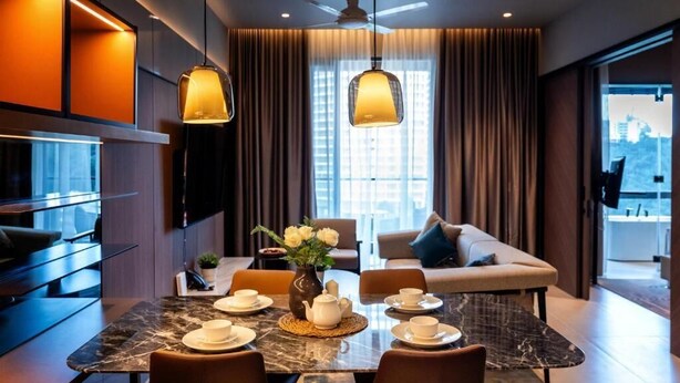 A modern hotel room with a dining area, a sofa, a TV, and a view of the city. - Antara Genting by Harvinton Mansion (Bentong)