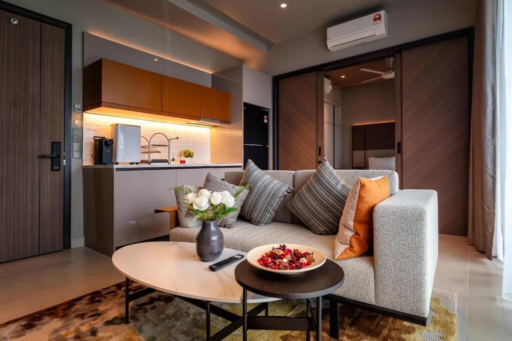 A modern living room with a sofa, coffee table, and a bowl of fruit.