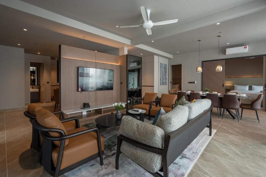 A modern living room with a sofa, chairs, a TV, and a dining area.