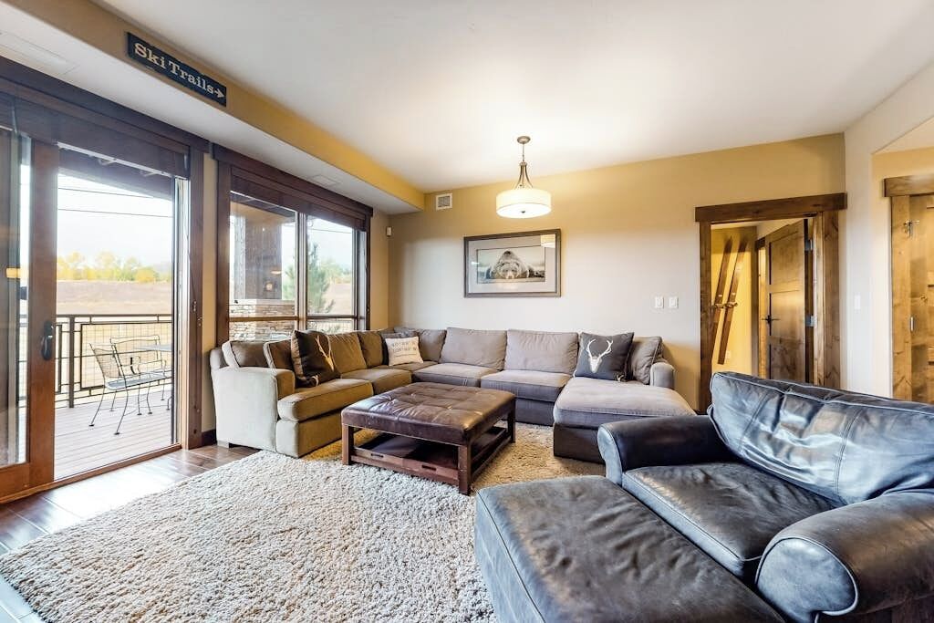 Een woonkamer met een bank, een bijzettafeltje en een groot raam.