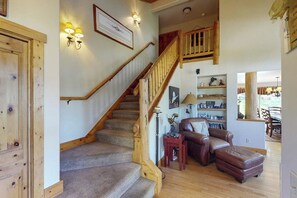 Eine Treppe mit hölzernen Geländern, ein Ledersofa und ein kleiner Tisch mit Dekoration.