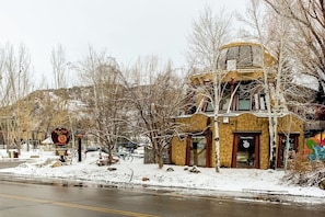 A building with a unique architectural design, a sign indicating a restaurant, and a snowy landscape. - Amazing Ski-In/Out Condo w/Balcony, Free WiFi, Fireplace, Shared Hot Tub, Pool (Steamboat Springs)