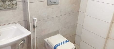 A bathroom with a sink, toilet, and shower area.