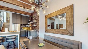 Eine moderne Küche mit Essbereich, Holzboden und einem großen Spiegel.