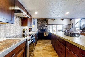 Eine Küche mit Holzschränken, einer Steinrückwand und Holzboden.