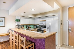 A modern kitchen with a central island, bar stools, and built-in appliances. - Second Floor Condo with Shared Pool and Hot Tub, Fast WiFi, and Gas Fireplace (Steamboat Springs)
