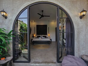 Ein Schlafzimmer mit Bett, Deckenventilator und zwei Wandlampen.