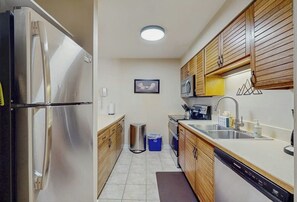 A compact kitchen with a stainless steel refrigerator, wooden cabinets, a microwave, and a dishwasher. - Lovely condo with shared pool, sauna, hot tub, tennis, free WiFi, gas fireplace (Steamboat Springs)