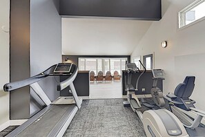 A fitness center with treadmills, a stationary bike, and a seating area with chairs. - Ski-in/ski-out mountain view condo with gas fireplace, hot tubs, & fitness room (Steamboat Springs)