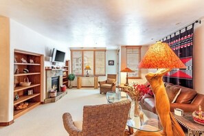 Ein Wohnzimmer mit Kamin, einer Couch, einem Couchtisch und einem Fernseher.