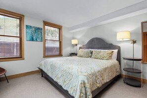 A bedroom with a bed, two bedside lamps, a nightstand, a chair, and a painting on the wall. - Downtown condo with rooftop deck, mountain views & W/D - walk everywhere (Telluride)