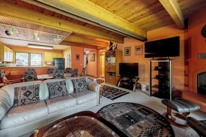 A spacious living area with a sofa, a television, and a fireplace.