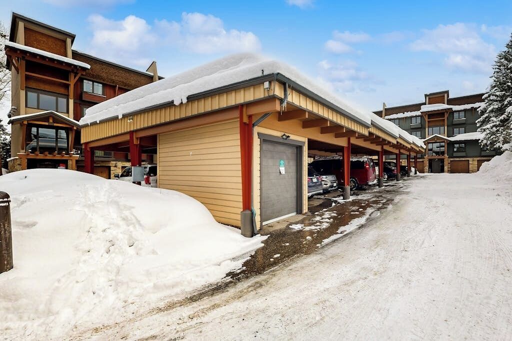 En bygning med parkeringsområde under tag og sne.