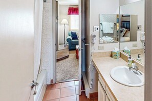 A bathroom with a sink, mirror, and toiletries. - Mountain getaway with modern comforts- pool, hot tub & summer activities (Steamboat Springs)