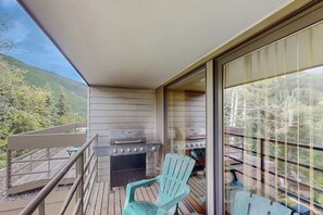 A balcony with a grill, chairs, and a view of a forested area. - Vail-View Condo w/ Balcony, BBQ, Large Indoor Pool-Near Skiing (Vail)