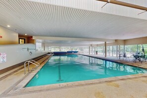 An indoor swimming pool with clear glass walls, a no diving sign, and a ceiling with a ribbed pattern. - Vail-View Condo w/ Balcony, BBQ, Large Indoor Pool-Near Skiing (Vail)