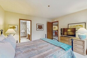 A bedroom with a bed, a television, a dresser, and a bathroom visible through an open door. - Townsend Place ski-in/ski-out condo, two blocks to Beaver Creek Village (Beaver Creek)