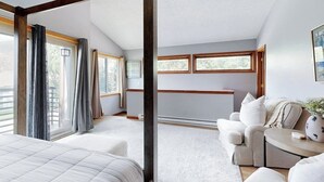 Un dormitorio con una cama grande, un sofá, una mesita y una ventana con cortinas.