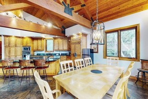 A spacious kitchen with wooden cabinets, a central island, and a dining area with a large table and chairs. - Huge Multi-Level Home with Hot Tub, Separate Studio Apartment & Vail Views (Vail)