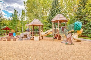 A playground with a slide, climbing structures, and covered areas. - Ground Floor Mountain Condo with Shared Pool & Hot Tub - Free Ski Shuttle (Avon)