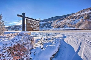 Schild für Brookside Signature Lofts, Lodge und Townhomes, mit verschneiter Landschaft im Hintergrund.