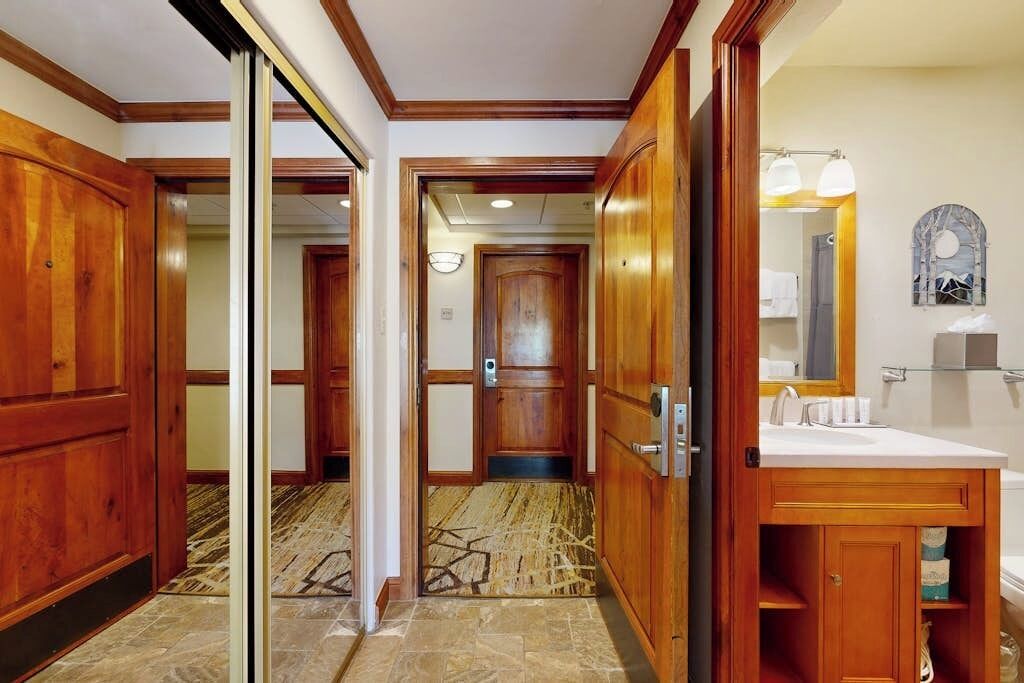Ett hotellbadrum med träinredning, ett handfat och en spegel.